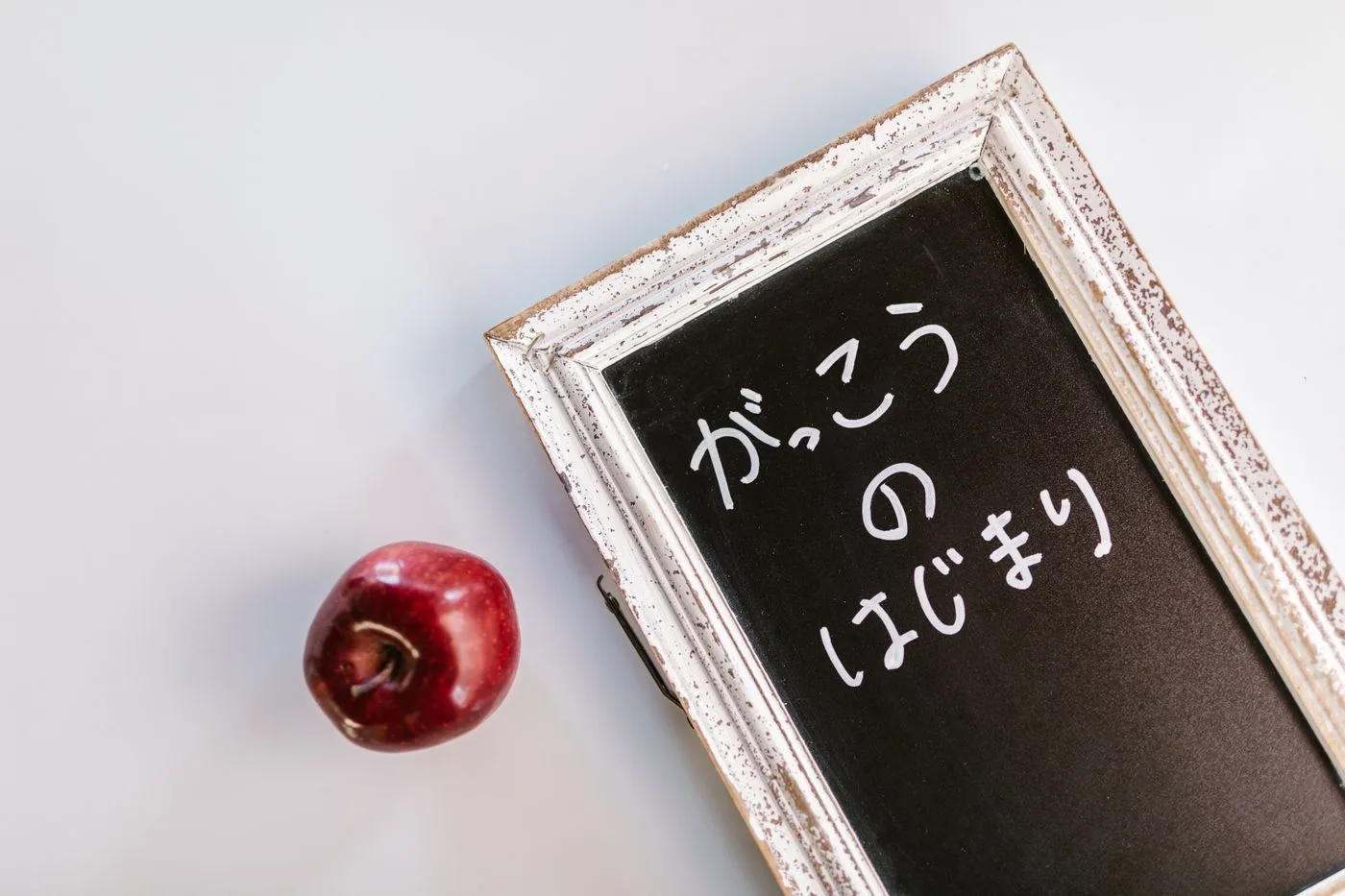 「がっこうのはじまり」と手書きされた小さな黒板と、隣に置かれた赤いりんご